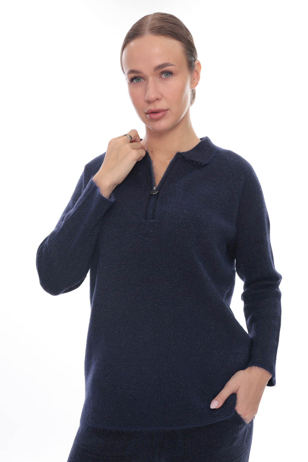 A woman modeling a dark navy blue long-sleeve knit polo-neck sweater with a short zipper at the collar, shown against a plain white background.
