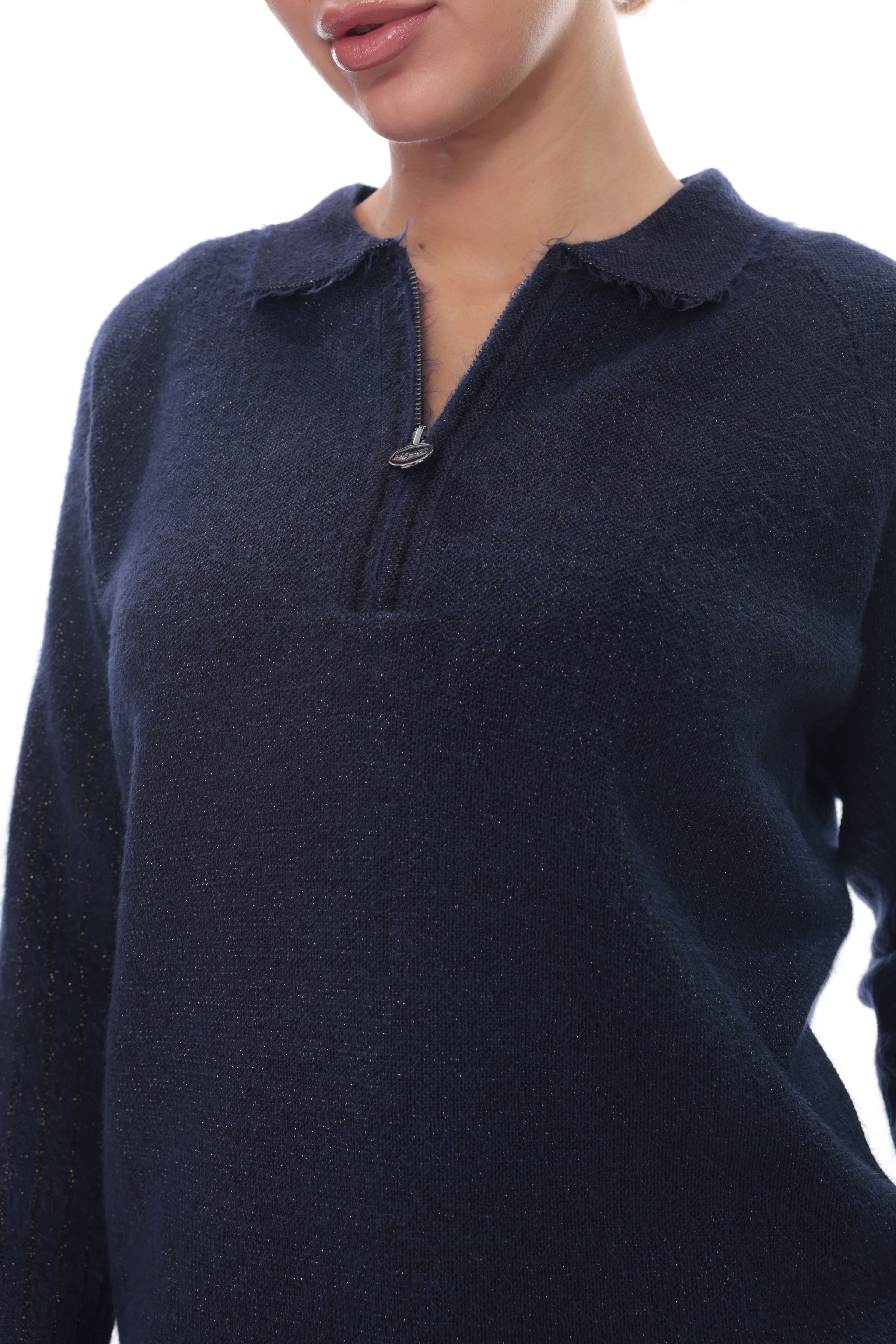 A close-up of a person wearing a dark navy knit sweater with a short zip neckline and a frayed collar, against a plain white background.