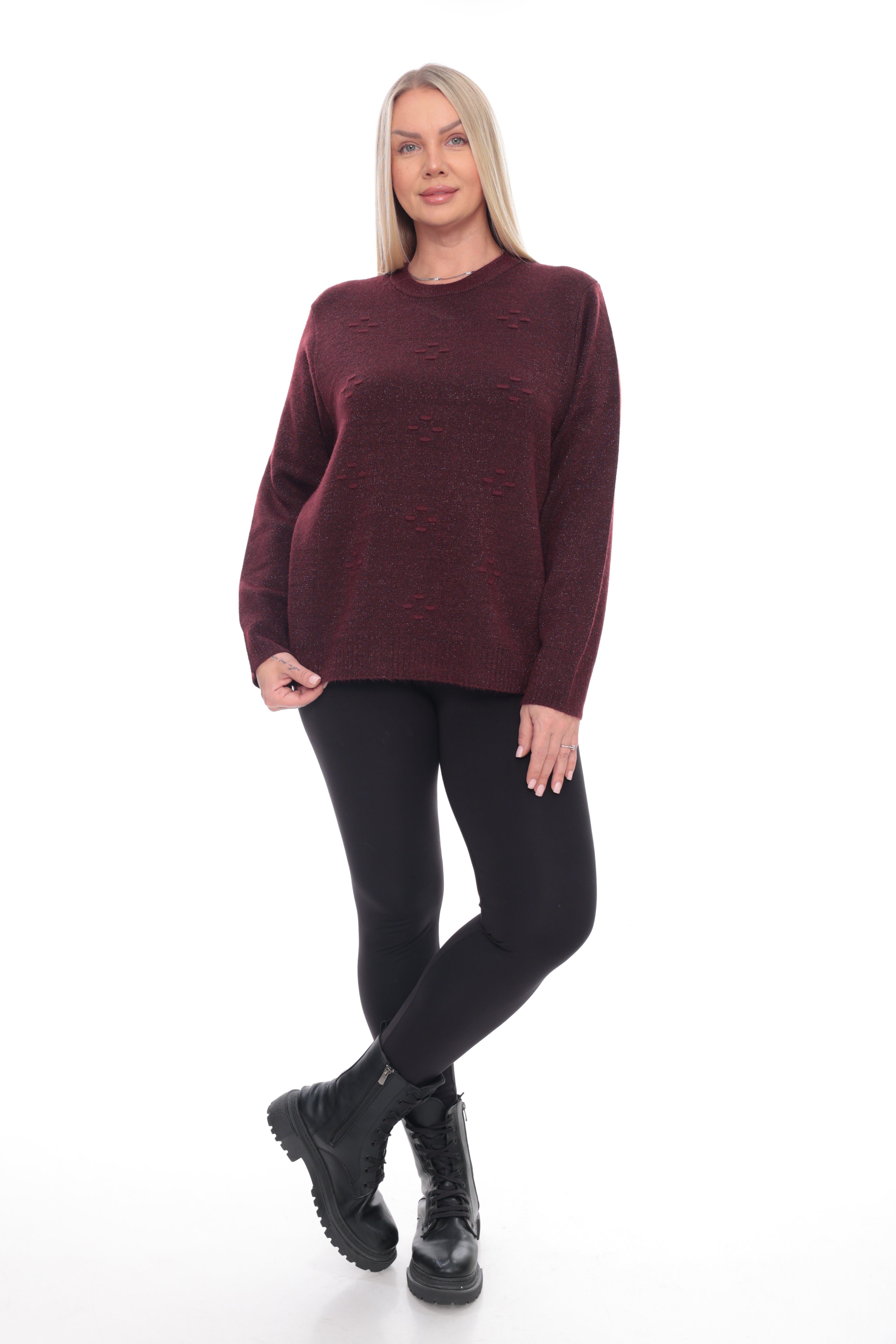 A woman modeling a maroon crewneck knit sweater, black leggings, and black combat boots against a plain white background.