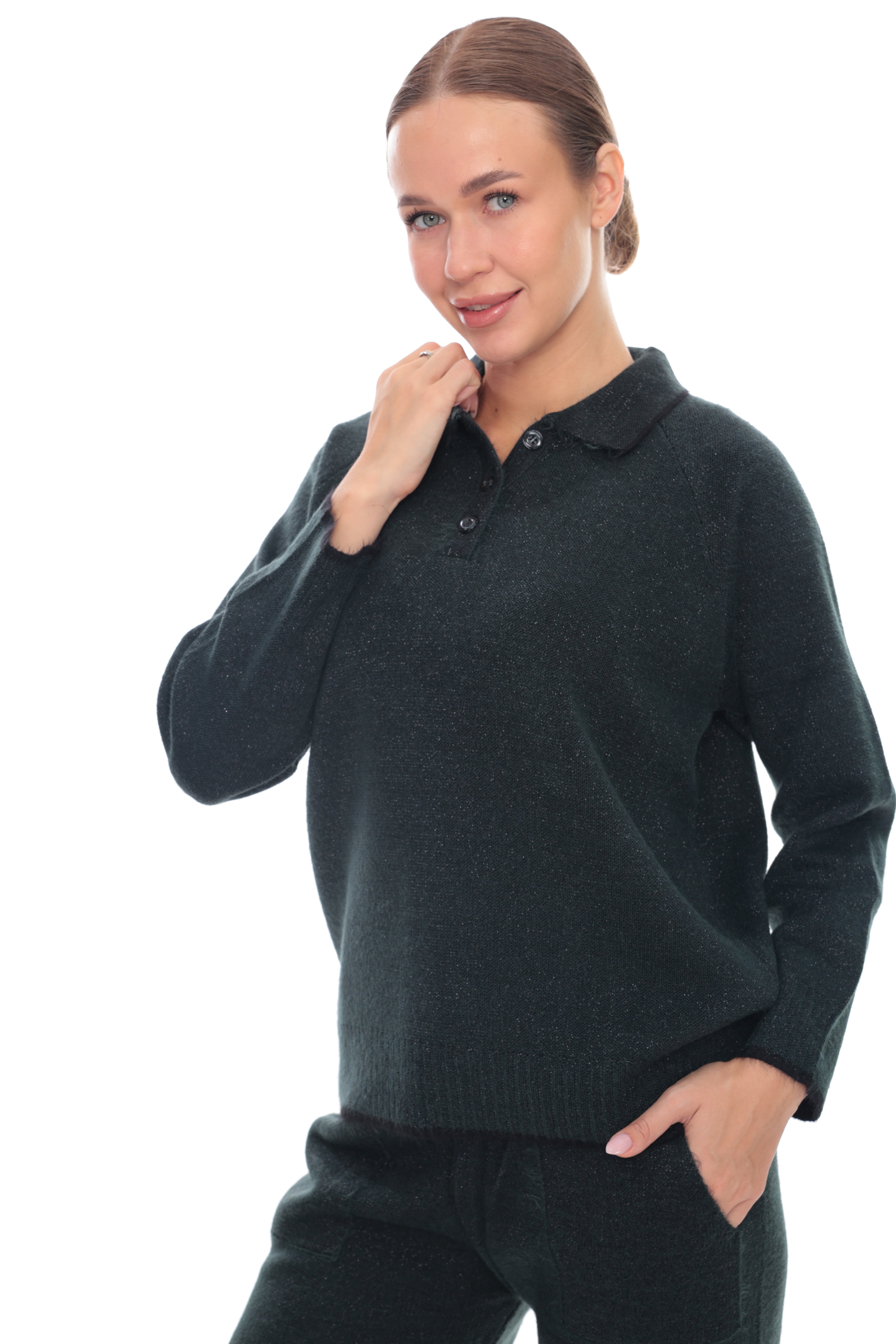 A woman modeling a dark charcoal gray knit polo sweater and matching dark pants against a solid white background.