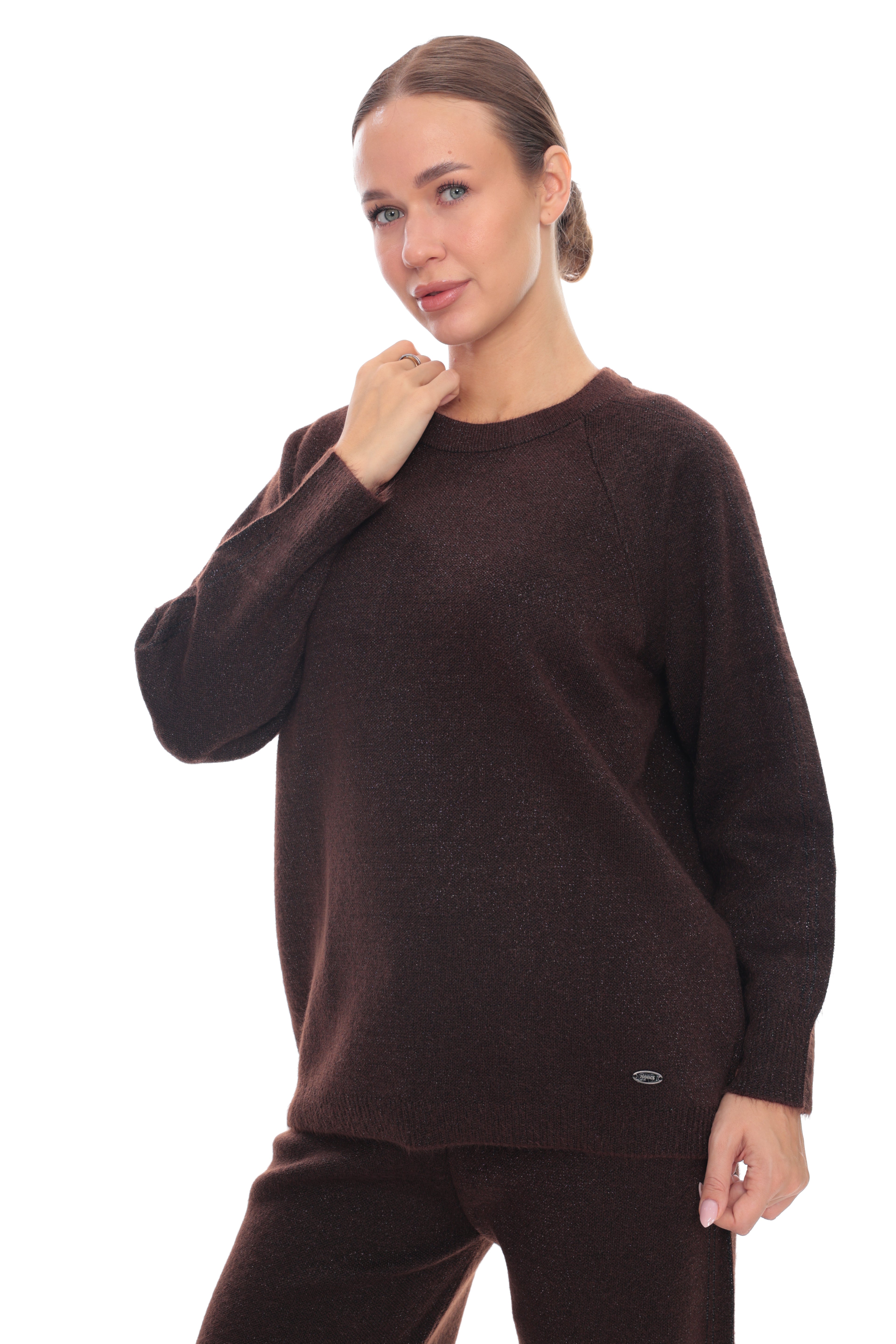 A woman modeling a dark brown knit crewneck sweater and matching pants against a plain white background.