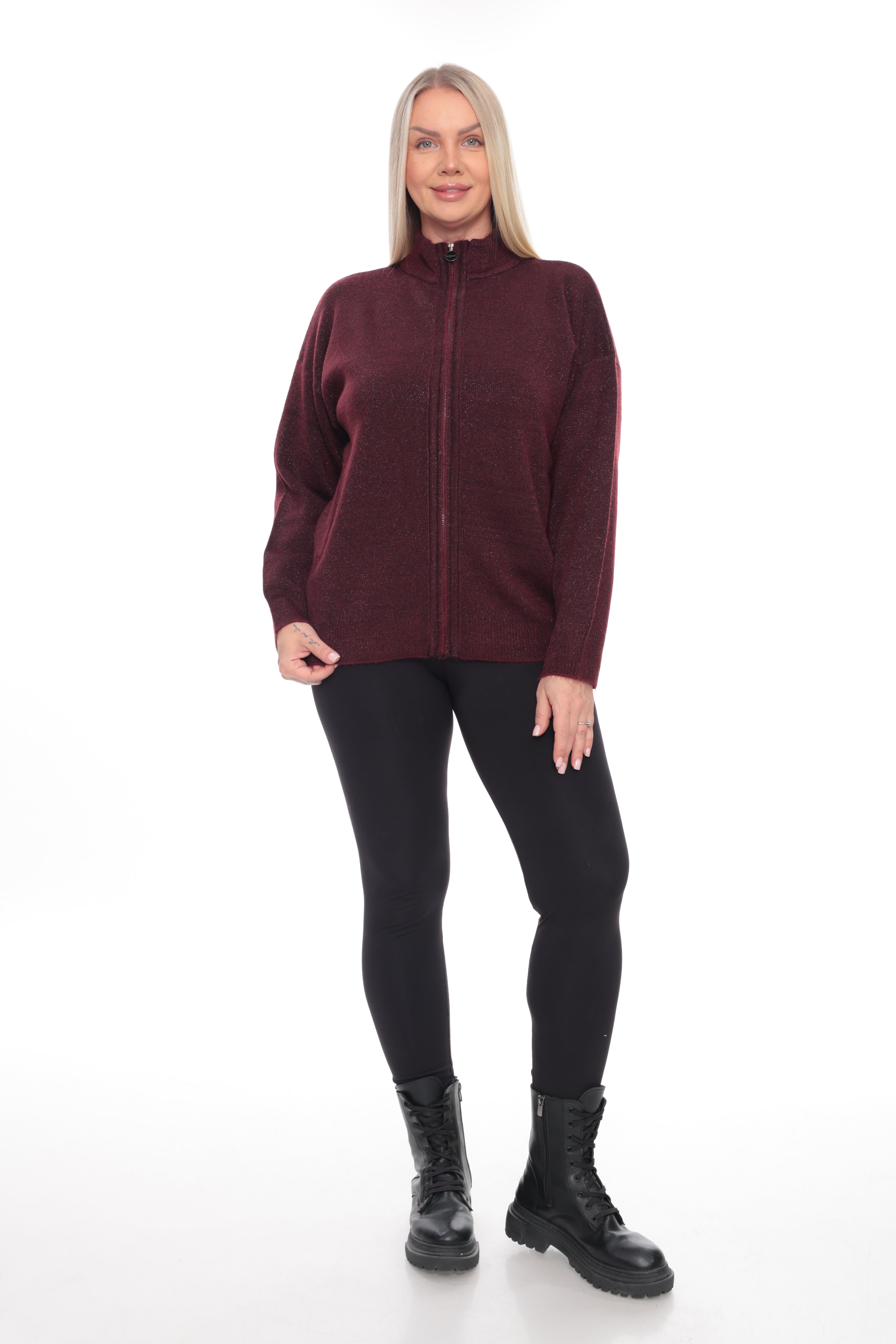 A woman modeling a maroon long-sleeve zip-up sweater, black leggings, and black boots against a plain white studio background.