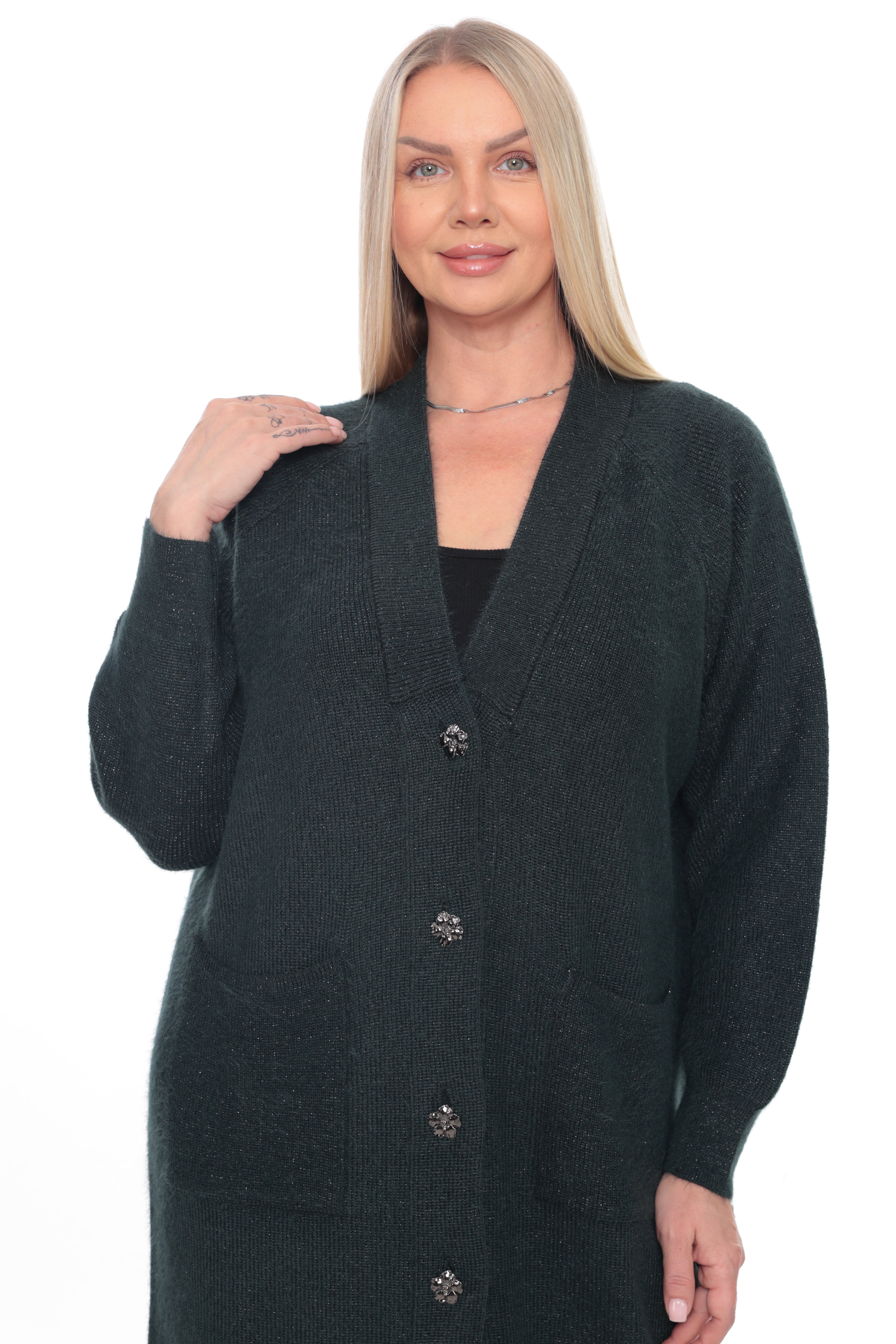 A blonde woman modeling a dark forest green knit cardigan sweater with decorative silver-tone buttons, shown against a plain white background.