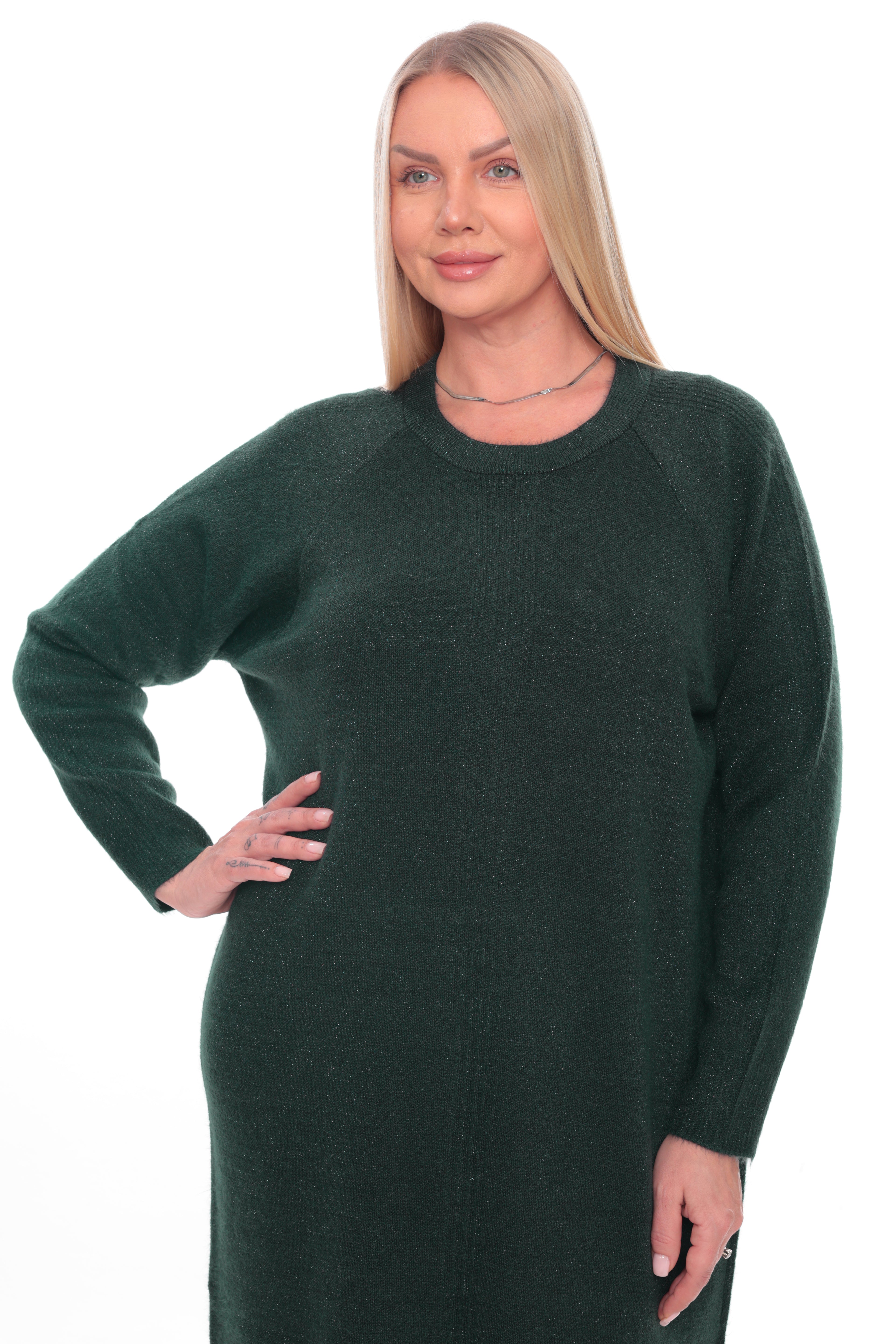 A blonde woman modeling a dark forest green long-sleeve knit sweater dress against a plain white background.