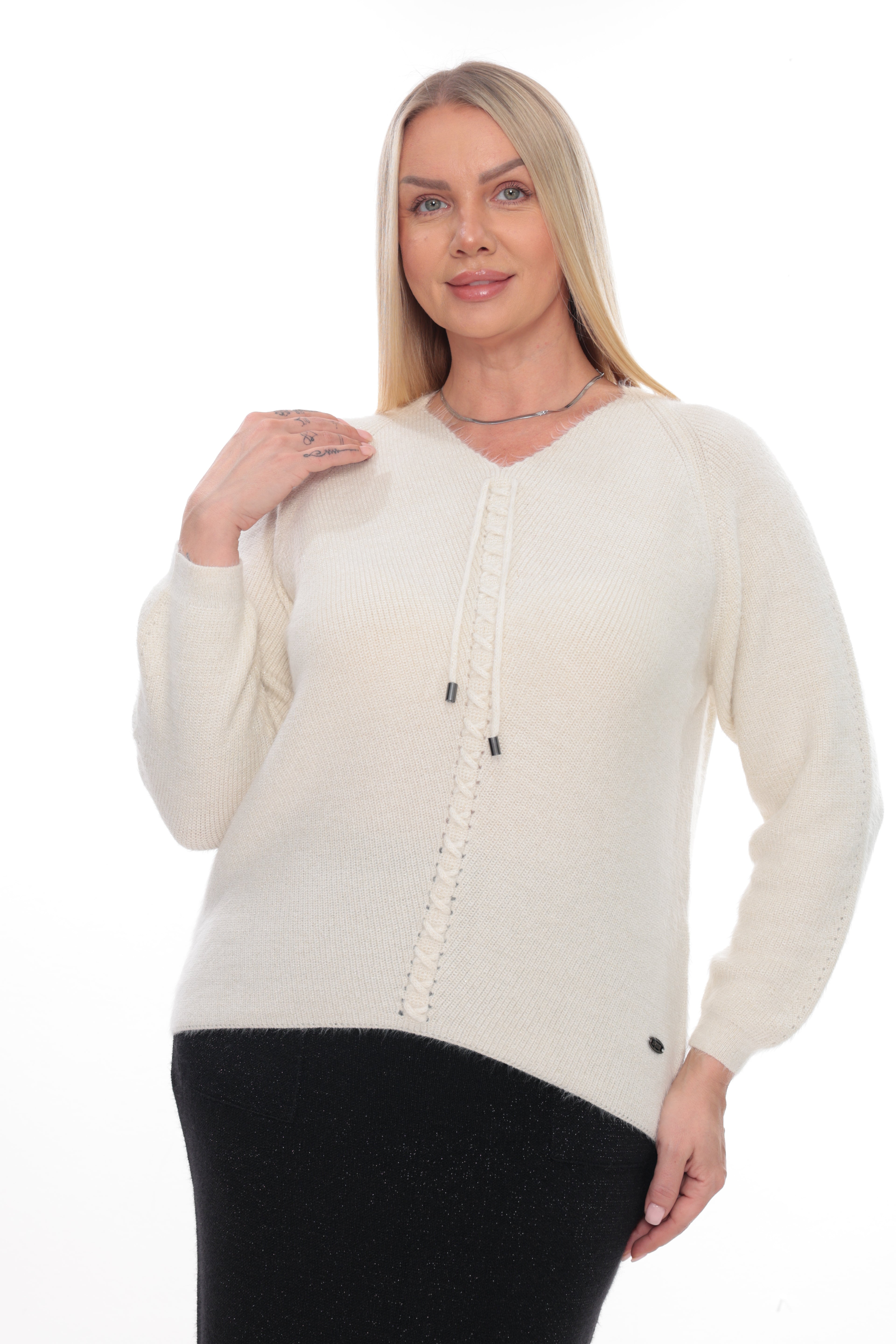 A blonde woman modeling a cream-colored knit sweater with a V-neck, long sleeves, and a decorative vertical textured stripe down the center front, paired with a black skirt against a plain white background.
